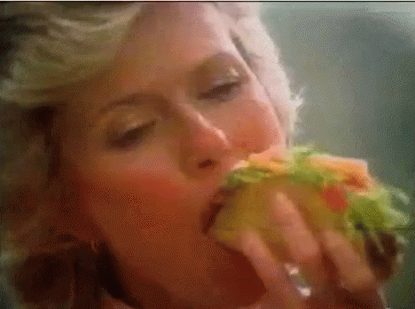 Woman Eating Sandwich With Eyes Closed