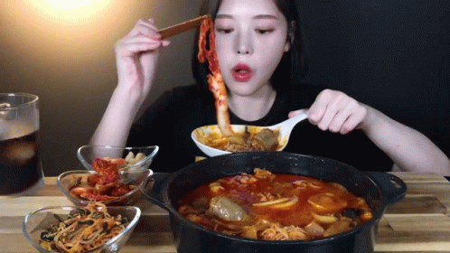 Woman Eating Stew With Spoon And Chopsticks GIF