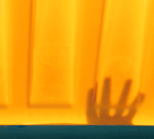 Woman Face Behind Yellow Curtain GIF