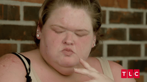 Woman Face With TLC Letters On Brick Wall GIF