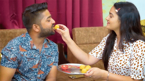 Woman Feeding Man Food from Plate