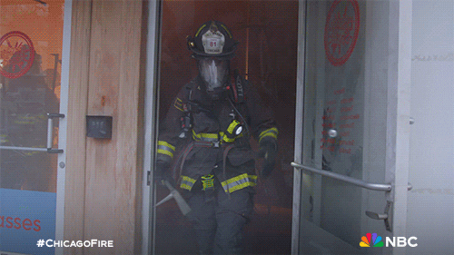 Woman Fire Fighter Getting Out Smokey Building GIF