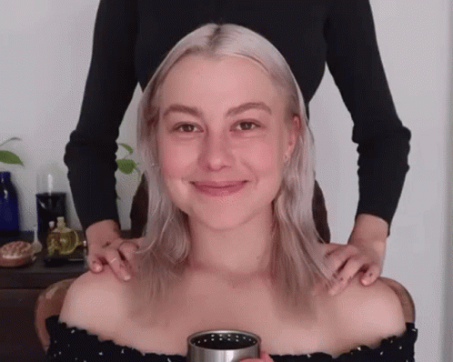 Woman Getting Massage From Another Holding Cup
