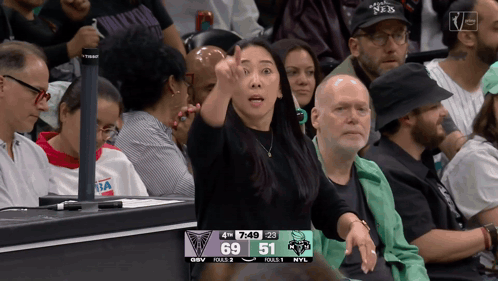 Woman Giving Thumbs Up in Front of Scoreboard 69 and 51