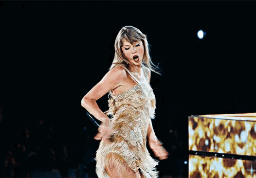 Woman Gold Dress Sings Into Microphone on Stage