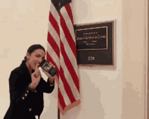 Woman Holding Book Beside American Flag GIF