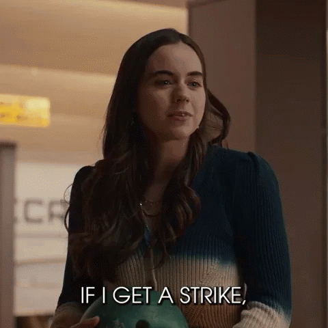 Woman Holding Bowling Ball Talking About Strike
