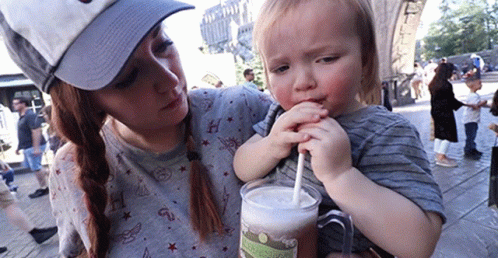 Woman Holding Boy Drinking from Mug