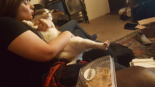 Woman Holding Cat Next to Lippin's Container