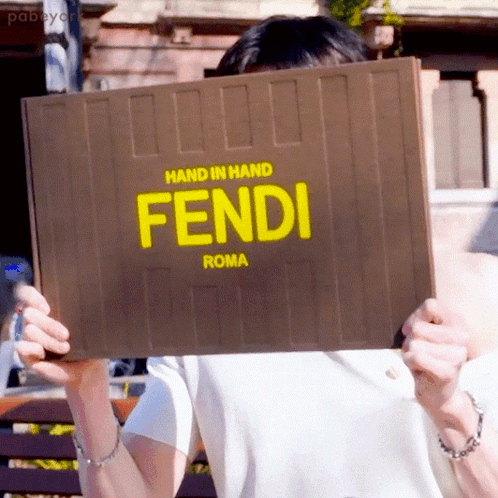 Woman Holding Cell Phone Next to Yellow Fendi Bag