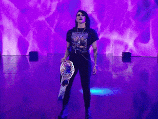 Woman Holding Championship Belt on Stage