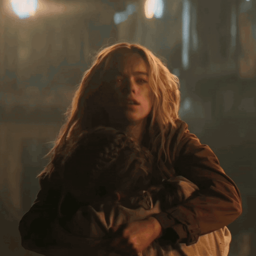 Woman Holding Child With Red Glowing Eyes GIF