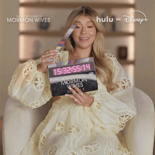 Woman Holding Clapper Board Saying Mormon Wives