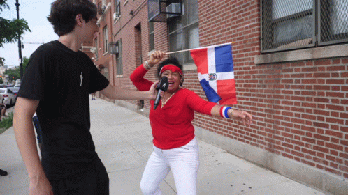 Woman Holding Flag and Microphone Interviewed by Man