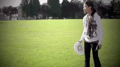 Woman Holding Frisbee in Field