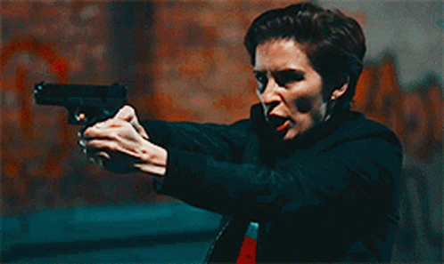 Woman Holding Gun Pointing at Camera