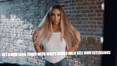 Woman Holding Hair In Front Of Brick Wall GIF