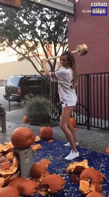 Woman Holding Hammer Near Pumpkins and Collab Sign