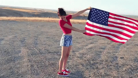 Woman Holding Large American Flag in Dirt