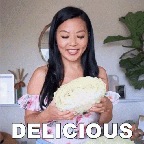 Woman Holding Large Cabbage Saying Delicious
