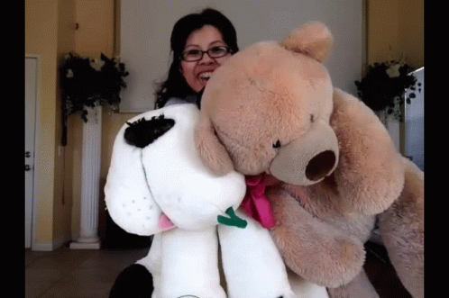 Woman Holding Large Teddy Bear and Stuffed Dog