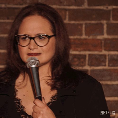Woman Holding Microphone at Netflix Brick Wall