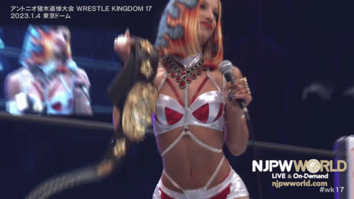 Woman Holding Microphone in Front of NJPW World Sign
