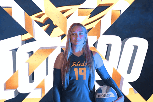 Woman Holding Molten Volleyball in Front of Toledo Logo
