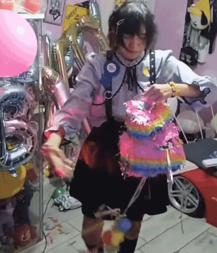 Woman Holding Pink Piñata Near Balloons And Sheep Sign GIF
