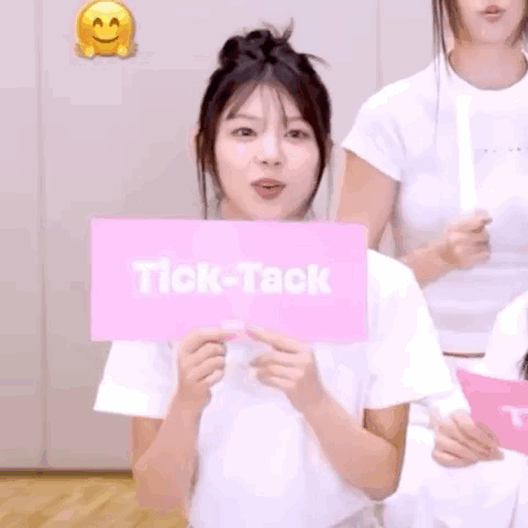 Woman Holding Pink Tick-Tack Sign Behind Face