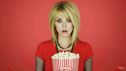 Woman Holding Striped Bucket of Popcorn
