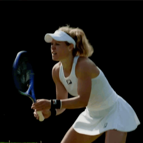 Woman Holding Tennis Racquet in White Fila Top