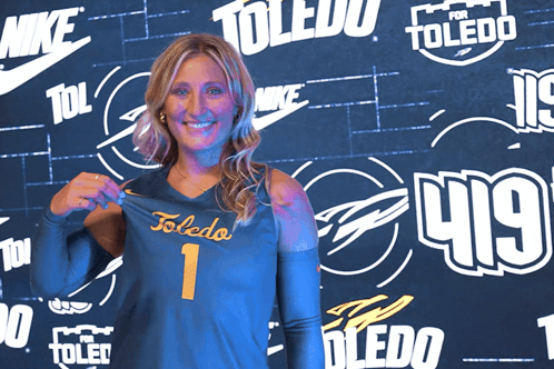 Woman Holding Toledo Jersey in Front of Nike Wall
