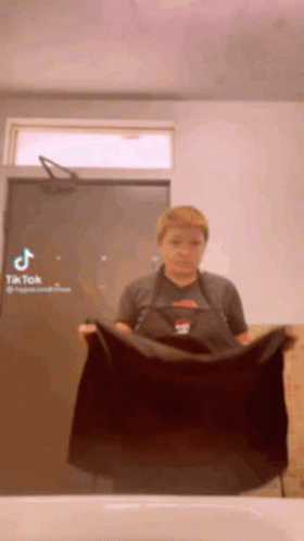 Woman in Apron Holding Black Towel