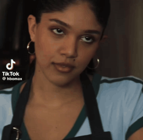 Woman In Apron With Hoop Earrings And TikTok Icon GIF