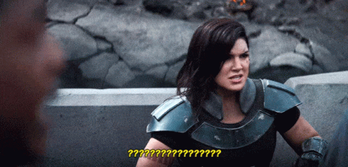 Woman in Armor Talking to Man with Question Mark