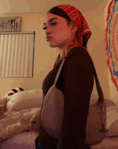Woman in Bandana and Purse Standing in Bedroom