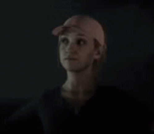 Woman in Baseball Cap Looking Up in Dark
