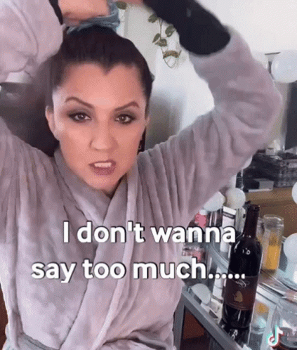 Woman In Bathrobe Holding Hair Bun Says I Don't Wanna Say Too Much GIF