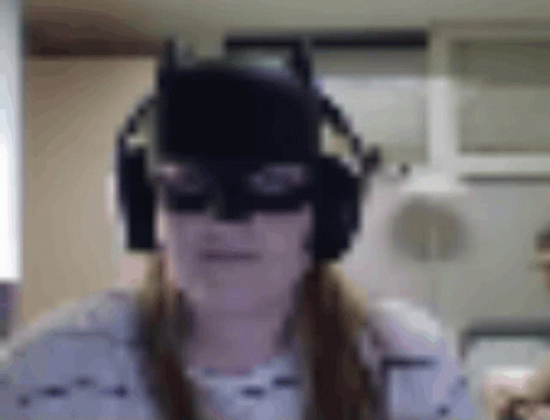 Woman in Batman Mask and Headphones Making Funny Face