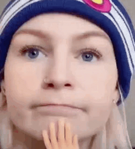 Woman In Beanie Holding Chin GIF