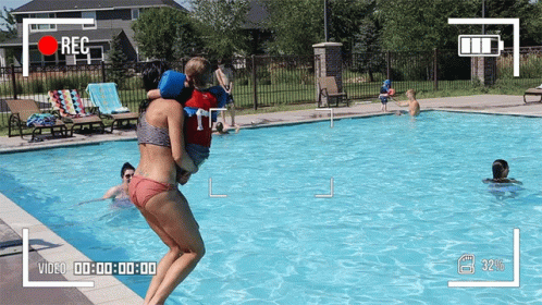 Woman in Bikini Carrying Child to Pool
