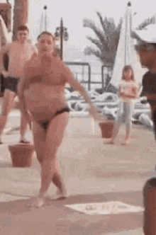 Woman in Bikini Dancing on Beach with Crowd