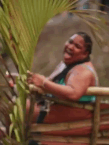 Woman in Bikini Laughing on Bamboo Fence
