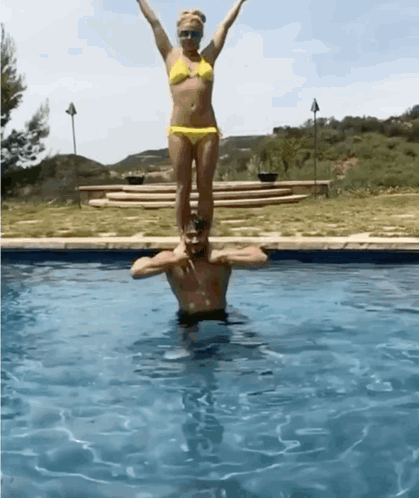 Woman In Bikini Standing On Man's Shoulders GIF