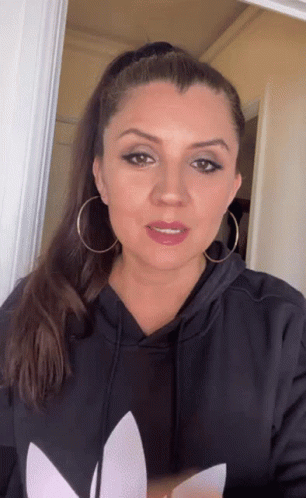 Woman in Black Adidas Hoodie and Earrings Looking at Camera
