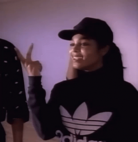 Woman In Black Adidas Sweater And Hat Pointing GIF
