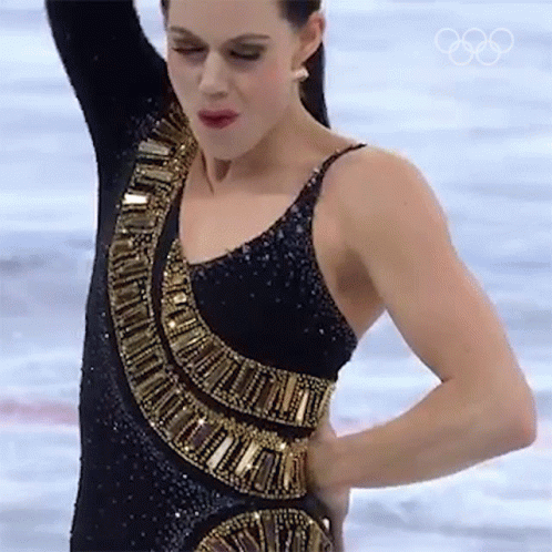 Woman In Black And Gold Dress On Ice With Olympic Rings GIF
