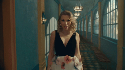 Woman In Black-And-White Dress Walking Hallway GIF