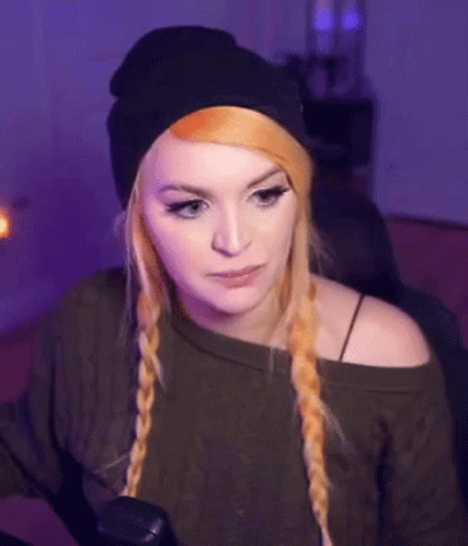 Woman in Black Beanie and Green Sweater Sitting in Chair